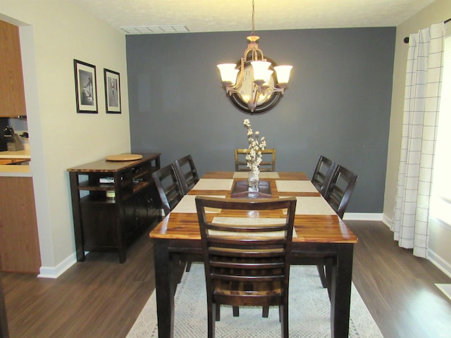 dining area with dark hardwood / wood-style floors and a chandelier