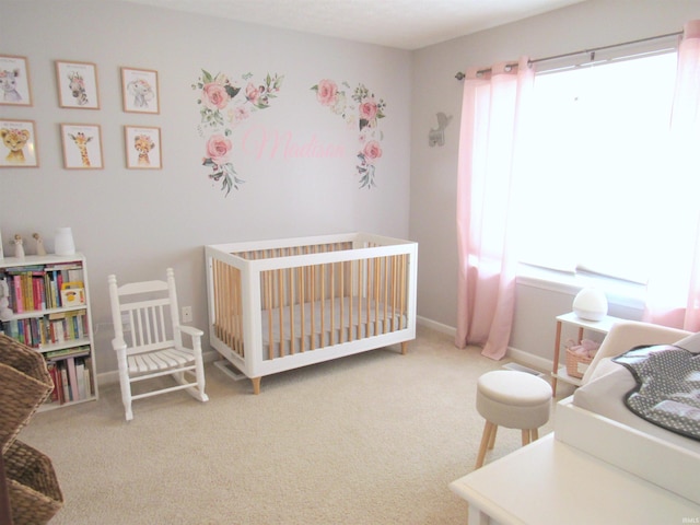 carpeted bedroom featuring a nursery area