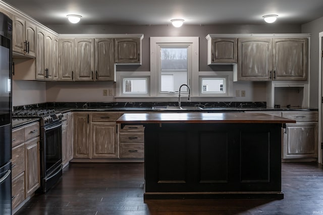 kitchen with dark hardwood / wood-style flooring, black gas range oven, sink, and wood counters