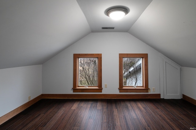 additional living space with vaulted ceiling and dark hardwood / wood-style flooring