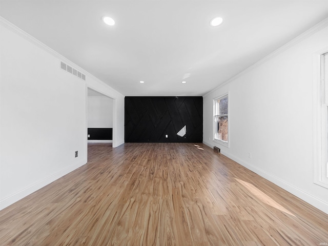 unfurnished living room with crown molding and light hardwood / wood-style floors