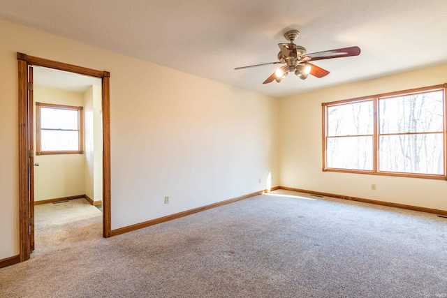 carpeted spare room featuring ceiling fan