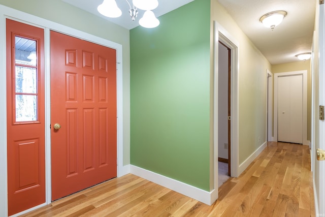 entrance foyer with an inviting chandelier and light hardwood / wood-style flooring