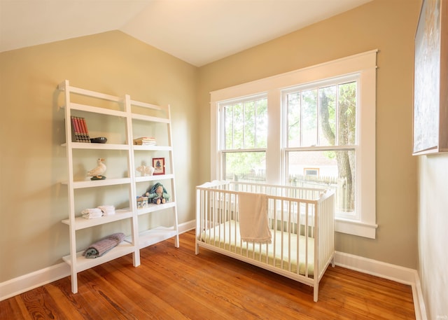 bedroom featuring lofted ceiling and hardwood / wood-style floors