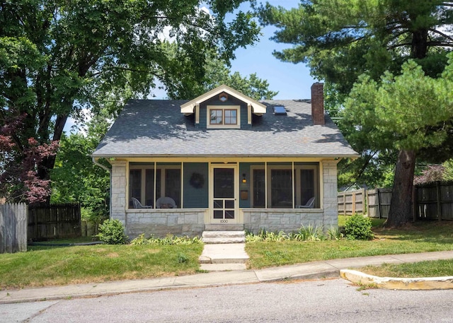 bungalow-style house with a sunroom and a front yard