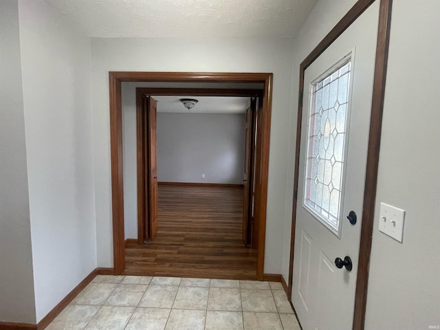 interior space featuring plenty of natural light, a textured ceiling, and light tile patterned floors