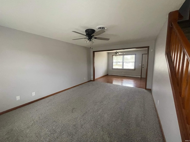 empty room with a baseboard heating unit, light colored carpet, and ceiling fan