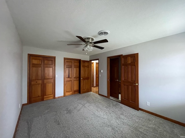 unfurnished bedroom featuring a textured ceiling, ceiling fan, and carpet