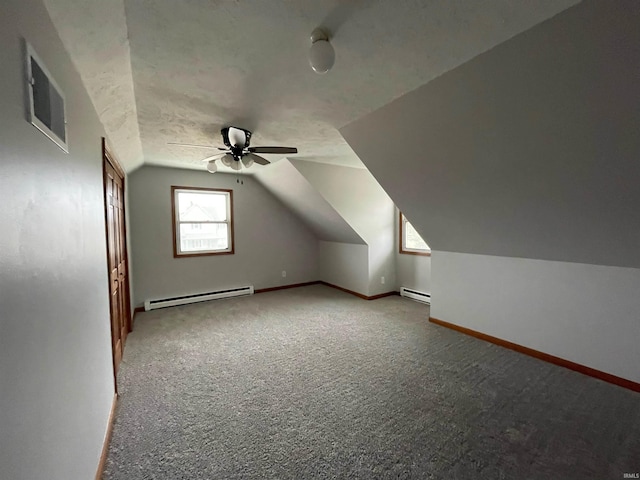 additional living space featuring light carpet, a baseboard heating unit, vaulted ceiling, and ceiling fan