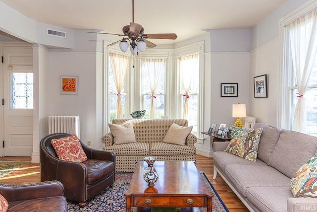 living room with hardwood / wood-style flooring, radiator, and ceiling fan