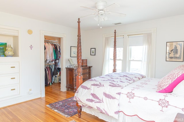 bedroom with ceiling fan, a closet, a spacious closet, and light hardwood / wood-style flooring