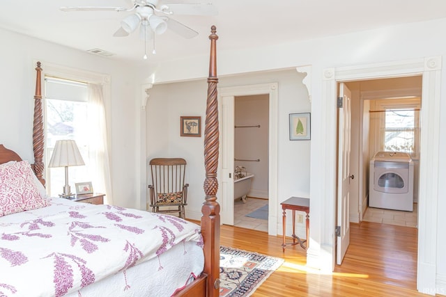 bedroom with ensuite bathroom, ceiling fan, wood-type flooring, and washer / dryer