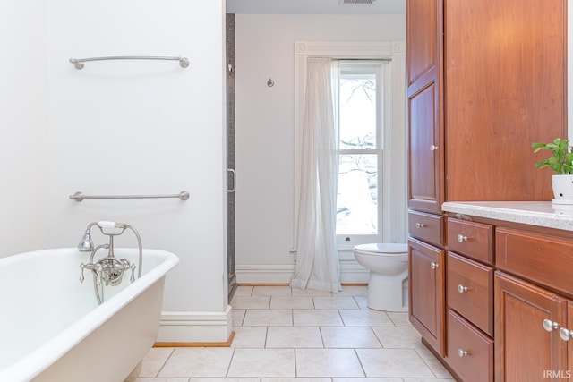 bathroom with plenty of natural light, a washtub, tile patterned floors, and toilet