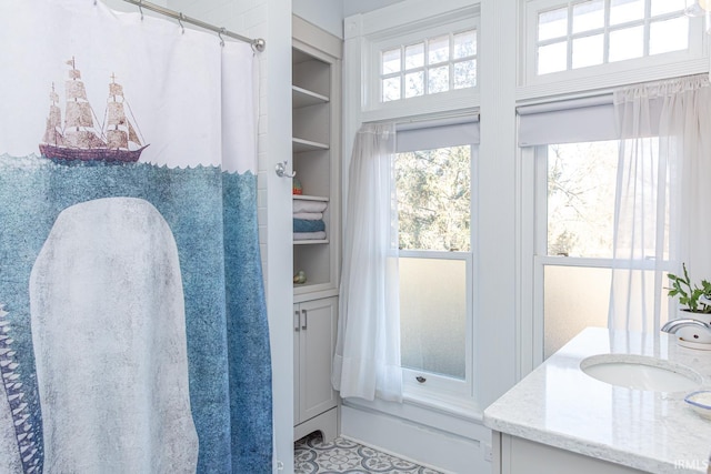 bathroom featuring built in shelves and vanity