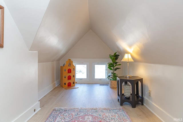 additional living space featuring lofted ceiling and light wood-type flooring