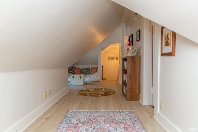 bonus room with vaulted ceiling and light hardwood / wood-style floors