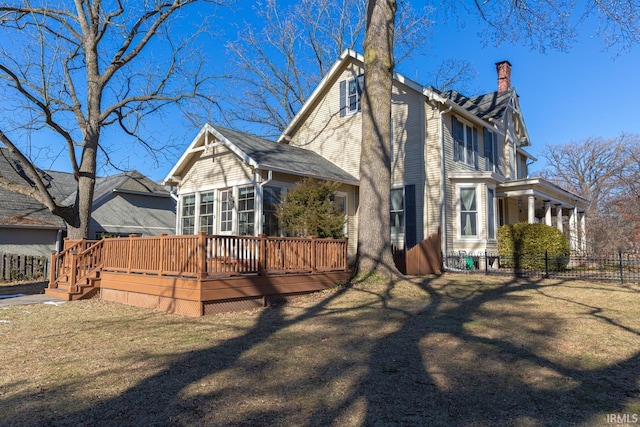 rear view of house with a deck and a lawn