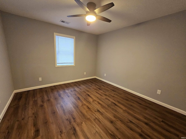 empty room featuring dark wood-type flooring and ceiling fan