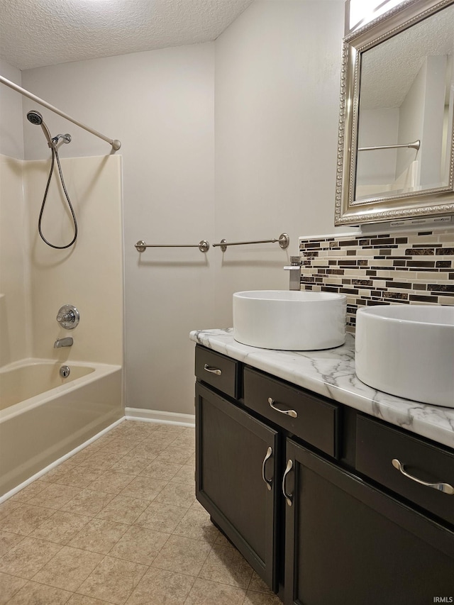 bathroom with tasteful backsplash, washtub / shower combination, vanity, and a textured ceiling