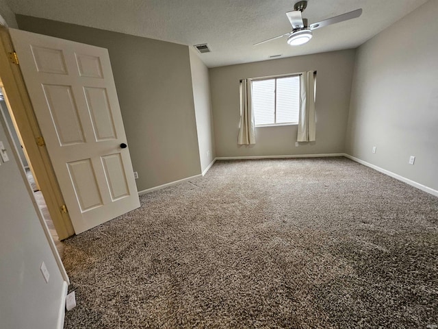 carpeted spare room featuring ceiling fan and a textured ceiling