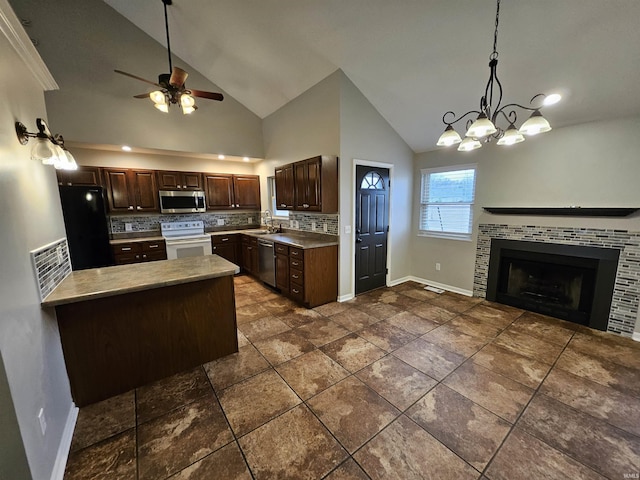 kitchen with appliances with stainless steel finishes, sink, backsplash, hanging light fixtures, and dark brown cabinets