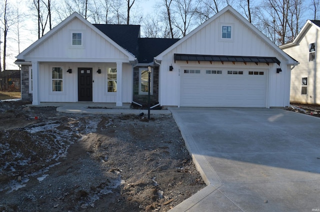 modern farmhouse featuring a garage and a porch