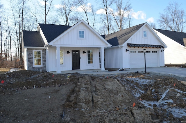 modern farmhouse style home with a garage and covered porch