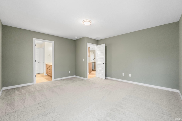 unfurnished bedroom featuring connected bathroom and light colored carpet