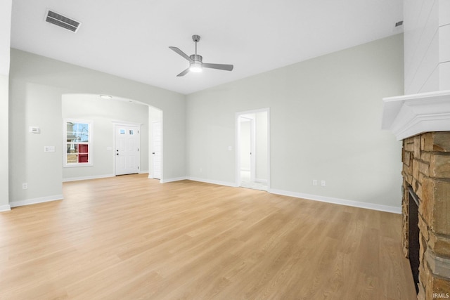 unfurnished living room with light hardwood / wood-style flooring, a fireplace, and ceiling fan