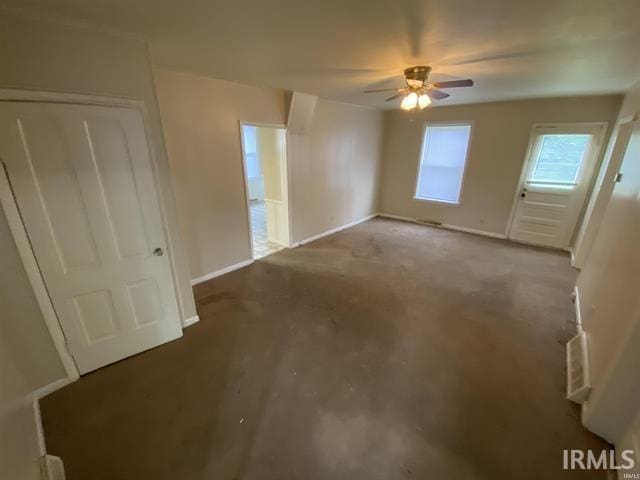 empty room featuring ceiling fan and concrete floors