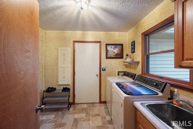 laundry area with sink, cabinets, independent washer and dryer, and a textured ceiling