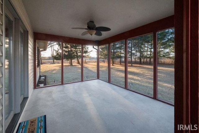 unfurnished sunroom featuring ceiling fan