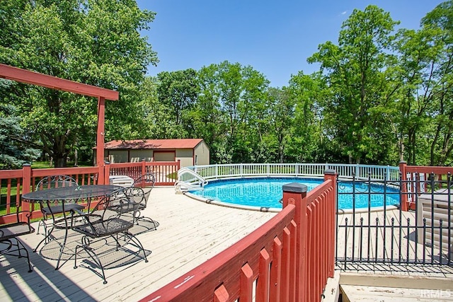 view of pool featuring a wooden deck and an outbuilding