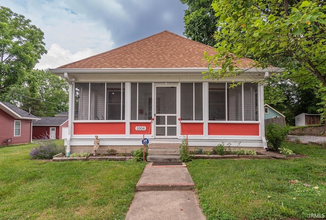 bungalow-style house featuring a front yard and a sunroom