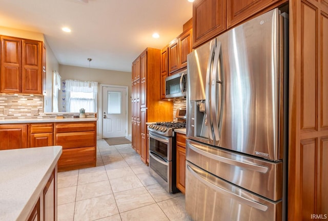 kitchen with pendant lighting, stainless steel appliances, light tile patterned flooring, and decorative backsplash