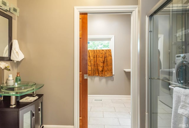 bathroom with tile patterned floors and a shower with door