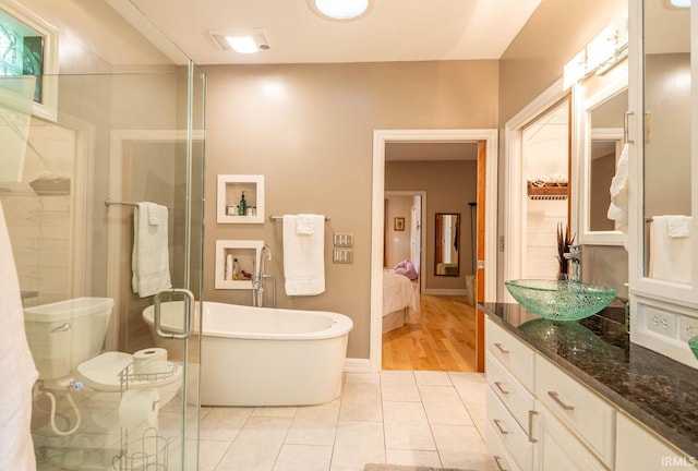 bathroom with vanity, a washtub, tile patterned floors, and toilet