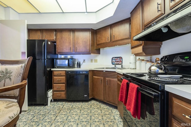 kitchen with a skylight, sink, and black appliances