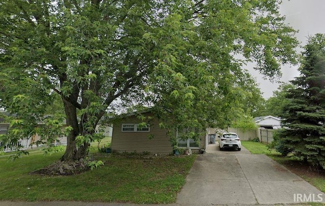 view of property hidden behind natural elements with a front lawn