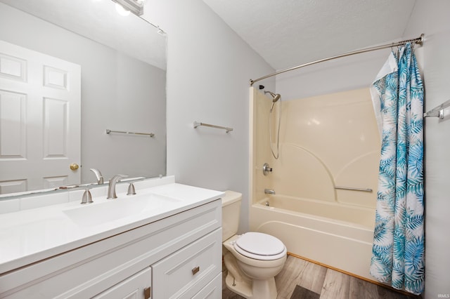 full bathroom featuring hardwood / wood-style floors, vanity, toilet, shower / bath combo, and a textured ceiling