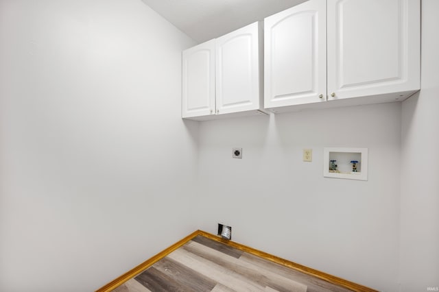 clothes washing area with cabinets, hookup for a washing machine, light hardwood / wood-style flooring, and electric dryer hookup