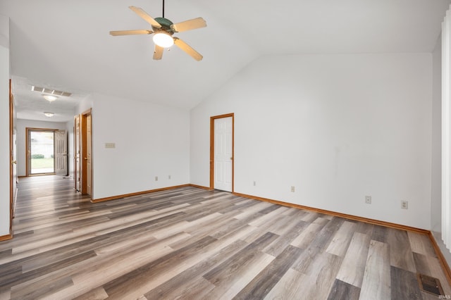 empty room with vaulted ceiling, ceiling fan, and hardwood / wood-style floors