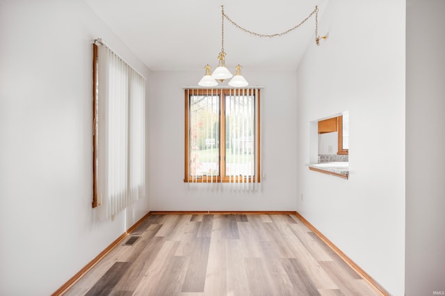 unfurnished room featuring light hardwood / wood-style flooring and a chandelier