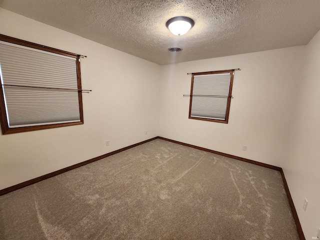 carpeted empty room with a textured ceiling