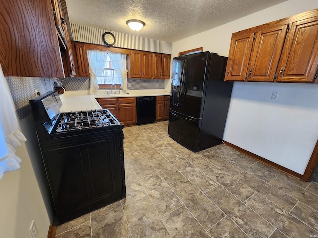 kitchen featuring sink, black appliances, and a textured ceiling