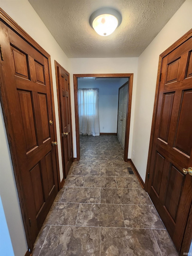 hall featuring a textured ceiling