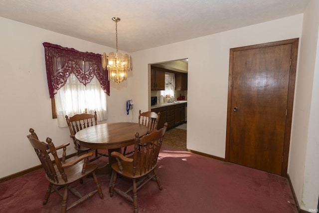 carpeted dining room with a chandelier and sink