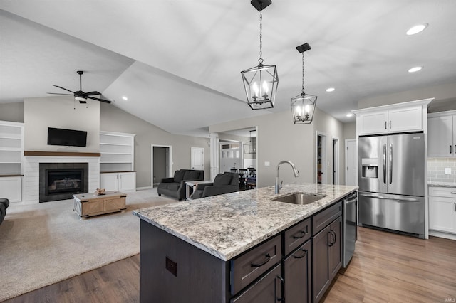 kitchen with pendant lighting, sink, white cabinetry, dark brown cabinets, and stainless steel appliances