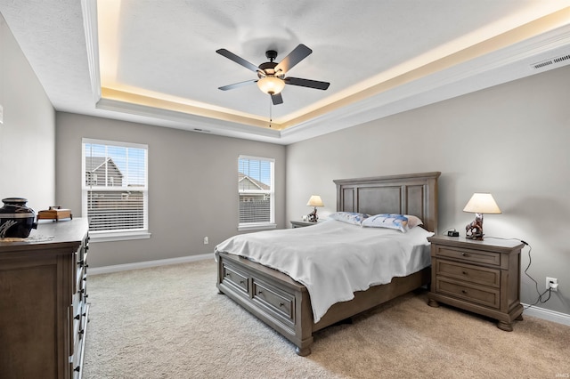 carpeted bedroom featuring a raised ceiling and ceiling fan