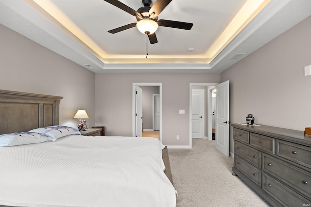 carpeted bedroom featuring a raised ceiling and ceiling fan